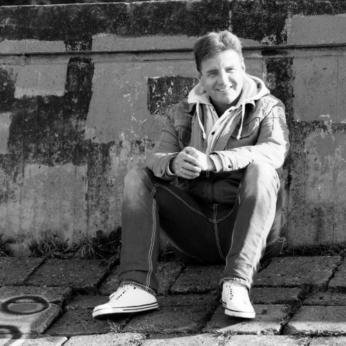 DJ Andre sitzt in Hamburg vor einer Wand